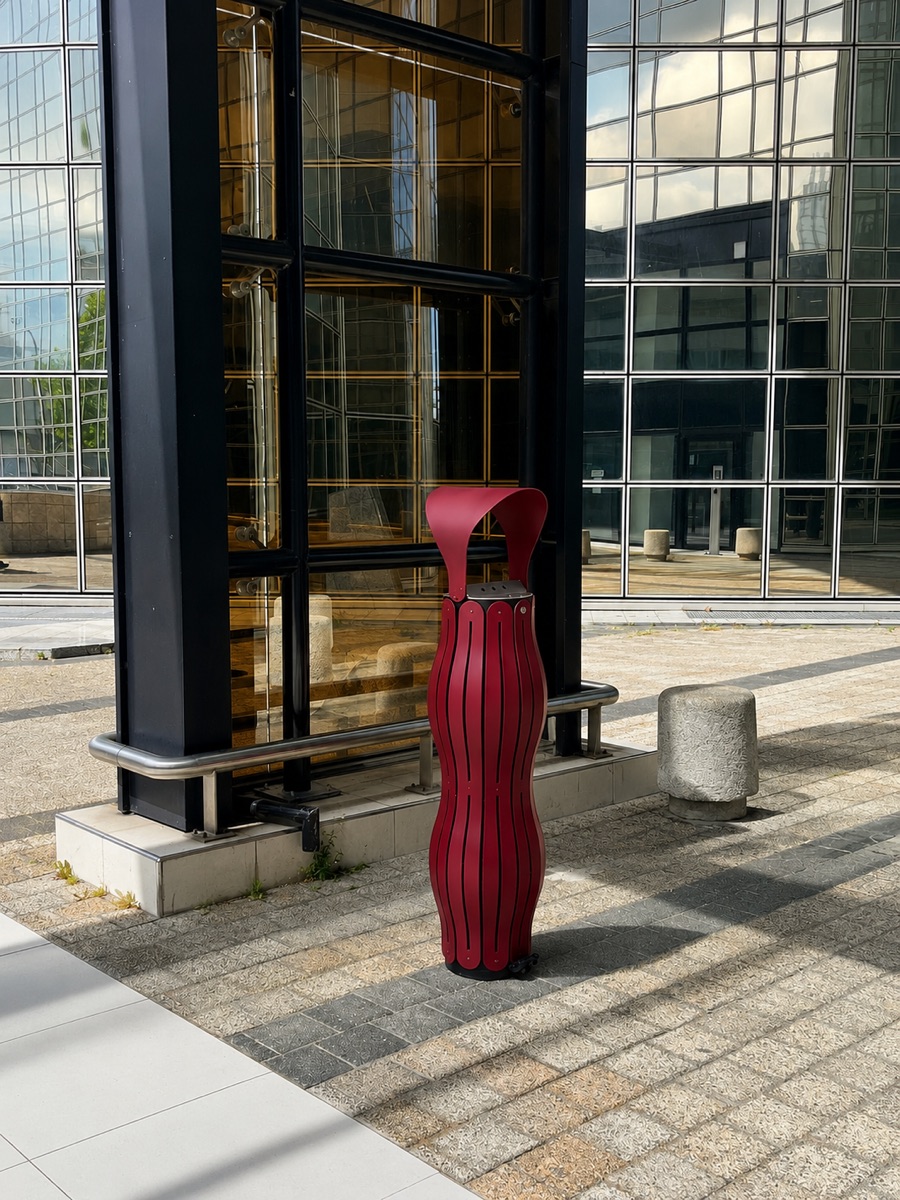 Cendrier bordeaux installé devant un bâtiment de bureaux